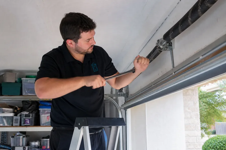Fast Lane Garage Doors technician replacing a broken torsion spring in Lewisville, TX